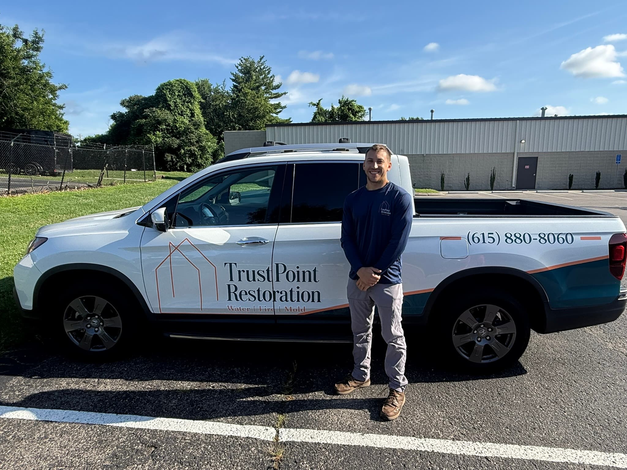 Brady Bushman, owner of TrustPoint Restoration, beside a company truck in Nashville